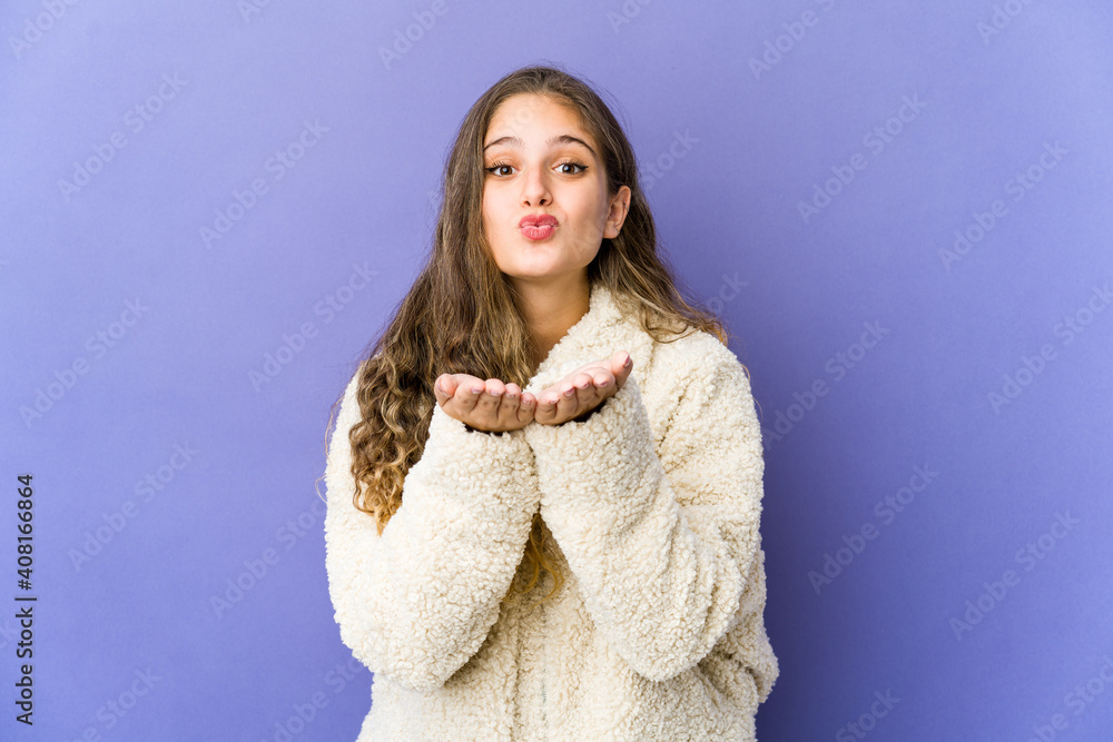 Young caucasian cute woman folding lips and holding palms to send air kiss. Young caucasian cute woman folding lips and holding palms to send air kiss.