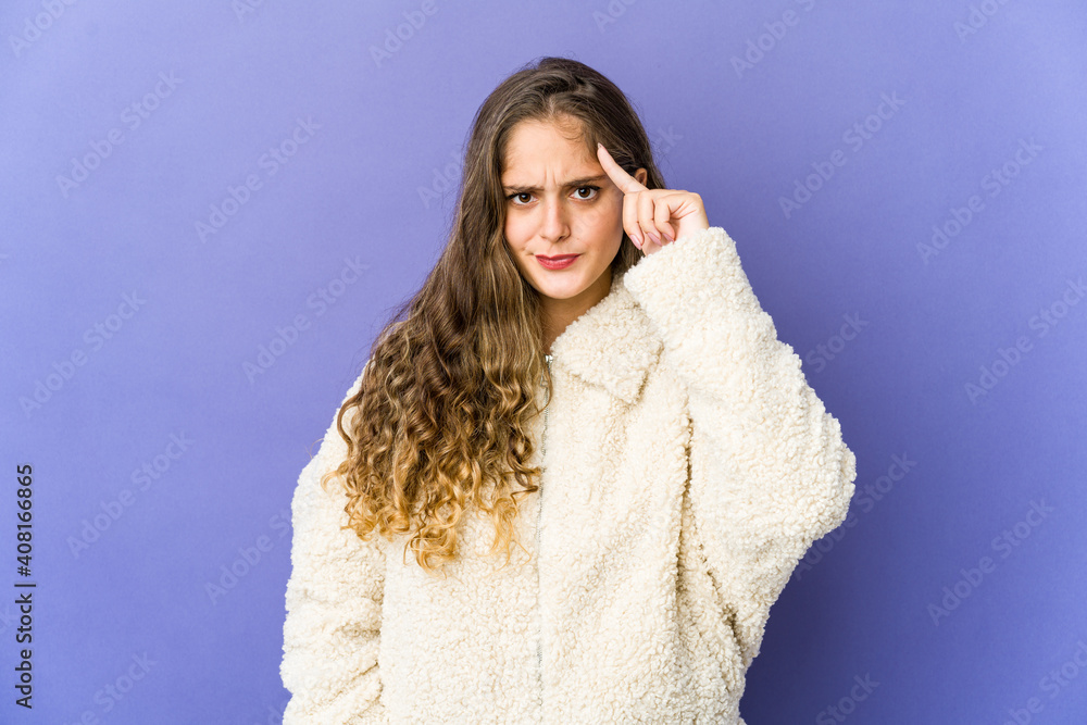 Young caucasian cute woman pointing temple with finger, thinking, focused on a task. Young caucasian cute woman pointing temple with finger, thinking, focused on a task.