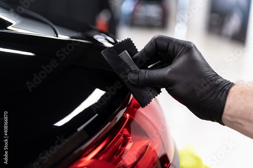 Obraz na płótnie Car detailing studio worker applying ceramic coating on car varnish w salonie