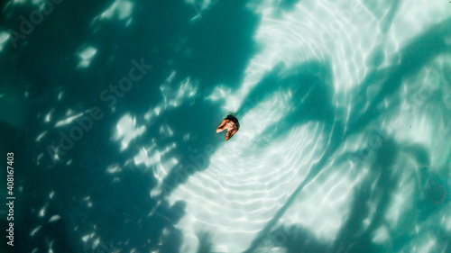 Aerial shot of woman at the pool covering the face with her hands
