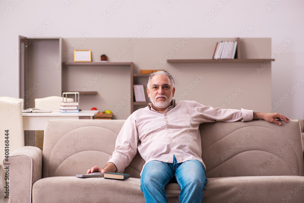 Old man sitting on the sofa at home Old man sitting on the sofa at home