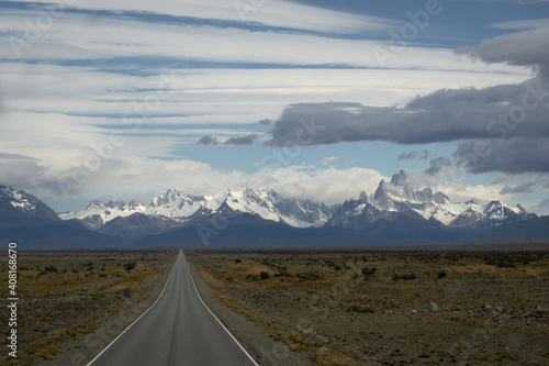 Asphalted road with the peaks of a rocky and snowy mountain on the horizon. Fitz Roy mountain in Argentina horizontal Photograph