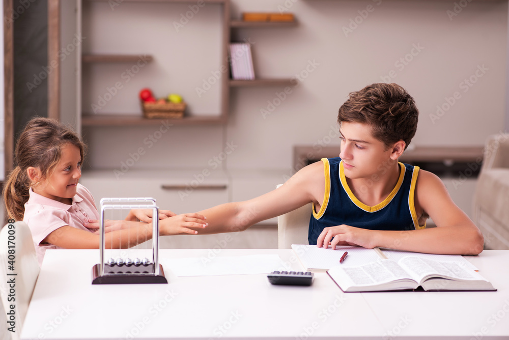 Schoolboy and his small sister staying at home during pandemic Schoolboy and his small sister staying at home during pandemic