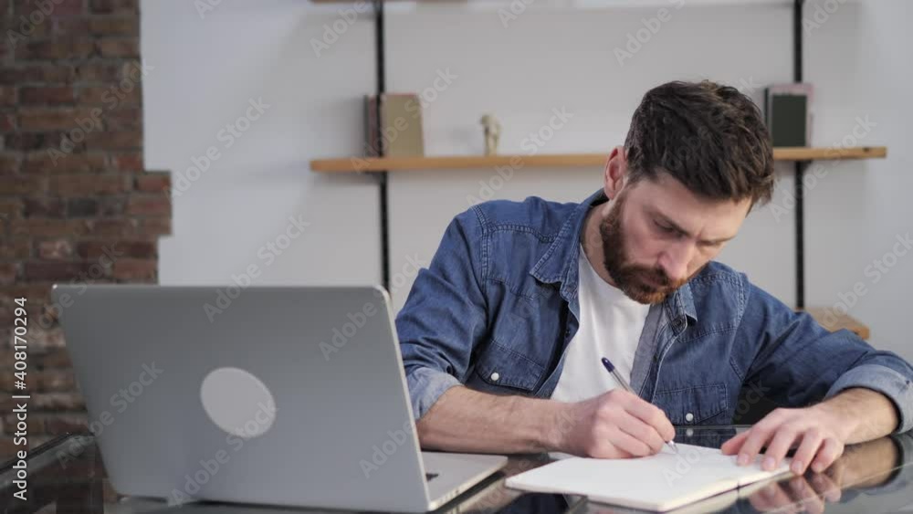 Young businessman working at home office using laptop computer making notes in notebook making mistakes in report feeling angry disappointed concerned anxious depressed experience failure data loss. Young businessman working at home office using laptop computer making notes in notebook making mistakes in report feeling angry disappointed concerned anxious depressed experience failure data loss.