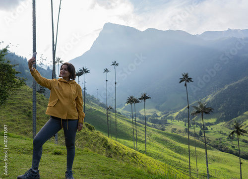 young lady hiker traveling and vlogging. A traveling woman takes a selfie with a landscape in the background. woman traveler in the cocora valley