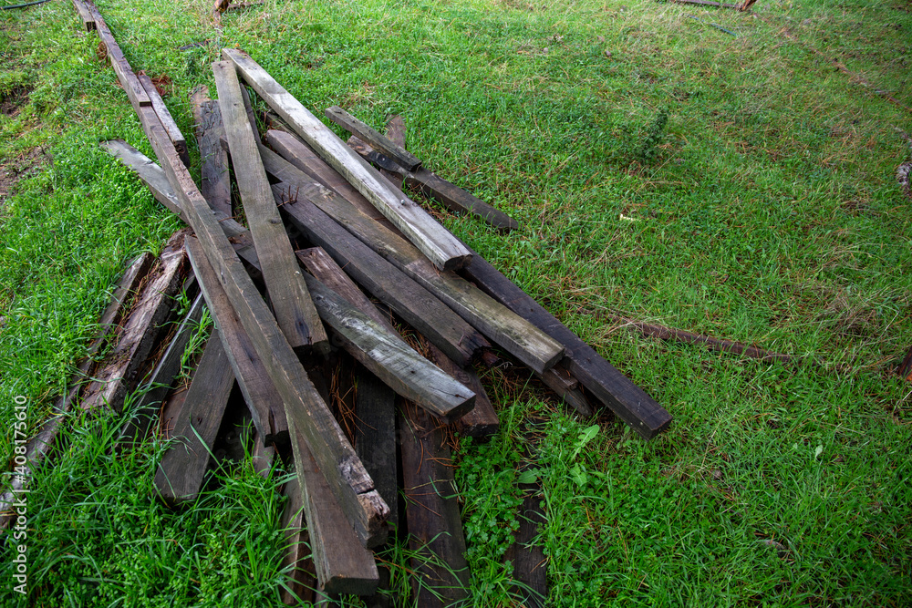 Stack of spiked boards standing on green grass.