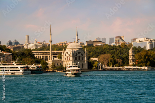 View on the bank of Bosporus Strait with touristic boat departing from Kabatas ferry terminal in front of Dolmabahce Mosque in Beyoglu district of Istanbul photo