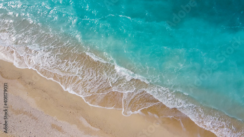 美しいアクアブルーの海と砂浜に白波が立つドローン俯瞰写真