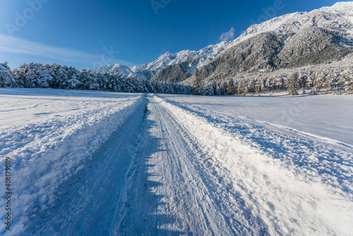 Deep snow covered walking path through alpine winter landscape in Wildermieming, Tirol, Austria