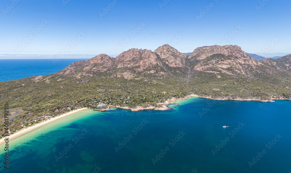 Stunning high angle aerial drone view of the famous Hazards mountain range, Richardsons Beach and Honeymoon Bay, part of Freycinet Peninsula and National Park in East Coast Tasmania, Australia.