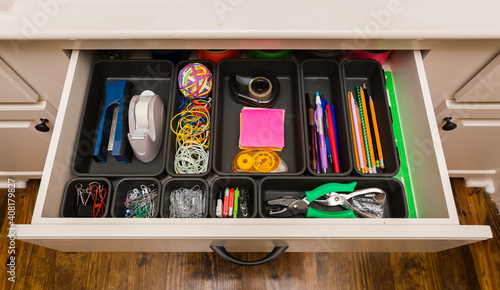 Fotografering Organized desk drawer with office supplies in bins