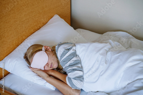 Woman sleeping in bed with the eye mask