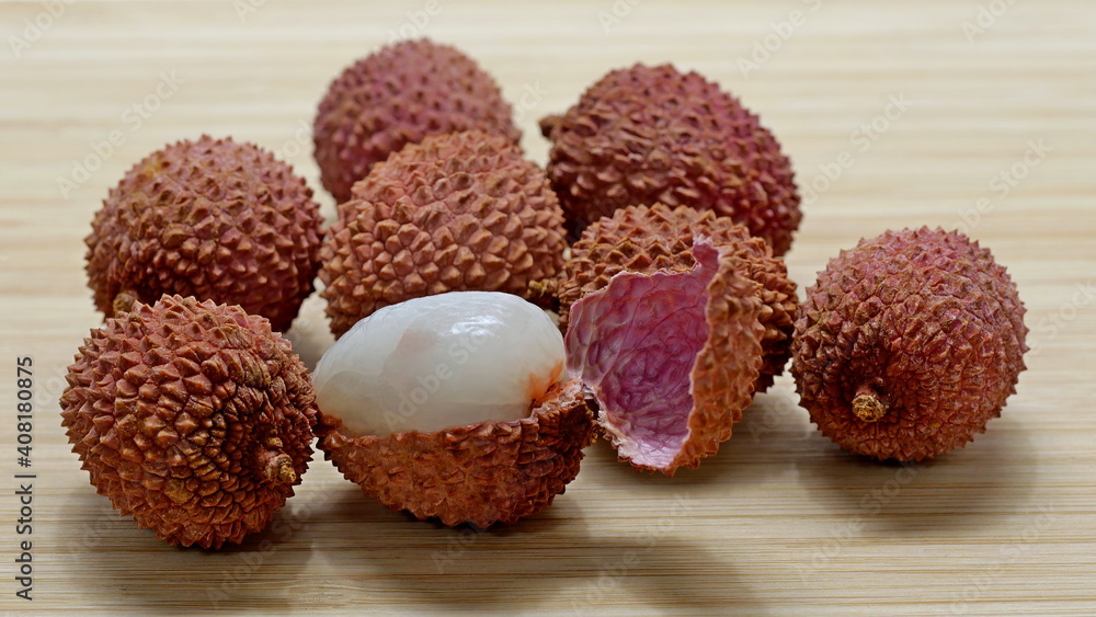 Several lychee fruits, one with open peel