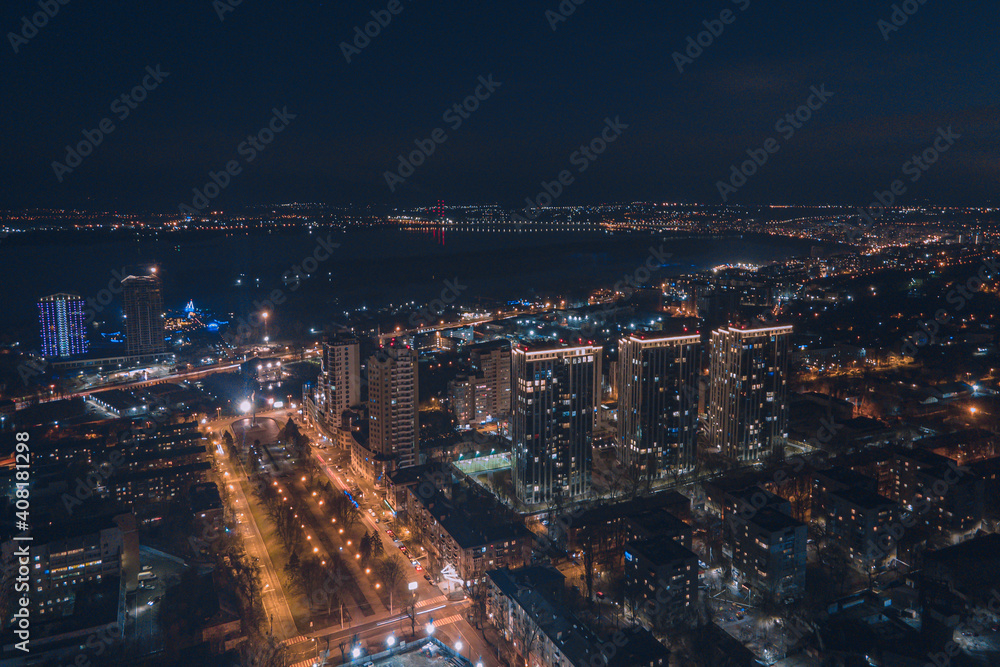 Drone view at night, with illuminated streets and dark sky. Beautiful cityscape