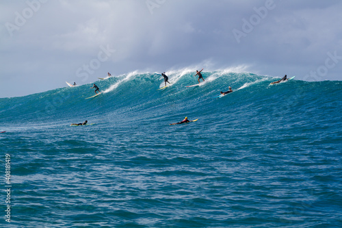 A group of Surfers riding a Wave in Hawaii