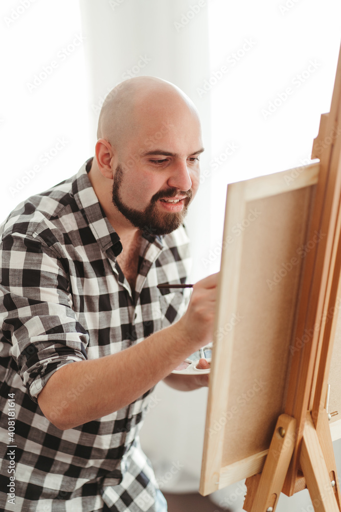 Fototapeta premium Young painter doing easel drawing at art studio