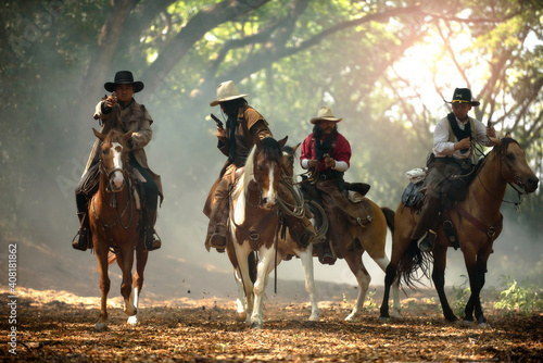 Cowboy riding a horse carrying a gunA western cowboy sitting on a horse © weerachai