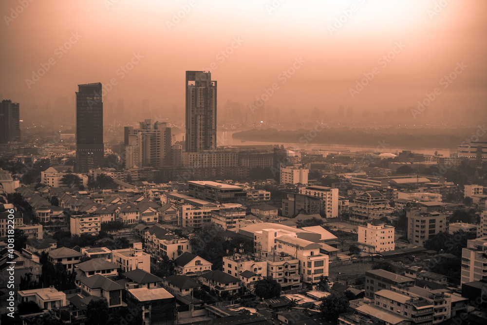Fototapeta premium The high angle background of the city view with the secret light of the evening, blurring of night lights, showing the distribution of condominiums, dense homes in the capital community