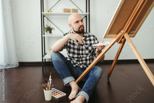 Creative home leisure. Man does easel drawing