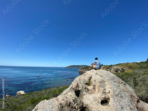 person on a rock ocean view California 