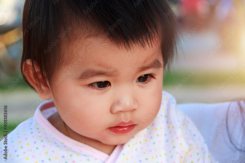 Close up portrait little girl. Cute adorable asian little girl play in park with sun ray background. Happy baby girl play in outdoor park. Close up and soft focus baby gril. Close up portrait little girl. Cute adorable asian little girl play in park with sun ray background. Happy baby girl play in outdoor park. Close up and soft focus baby gril.