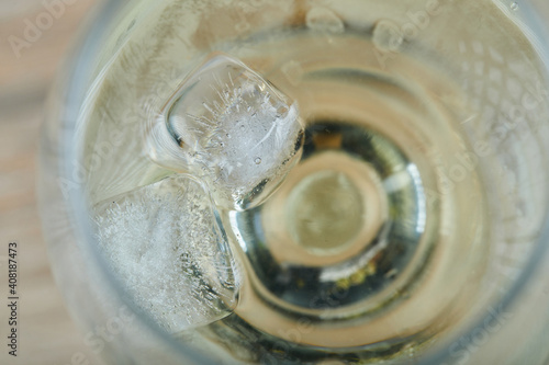 A glass of white wine on wooden background, close up