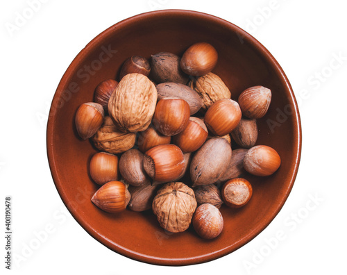 Bowl with different nuts, walnuts, hazelnuts and pecan, isolated on white