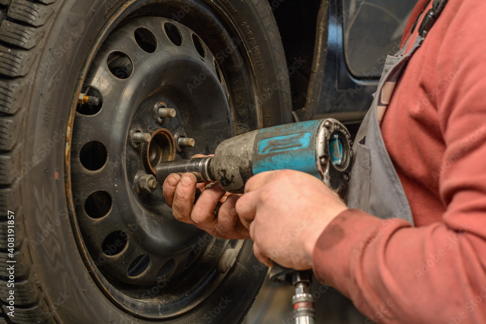 Handyman In Tire Changing In A Power Station With A Impact Driver Stock