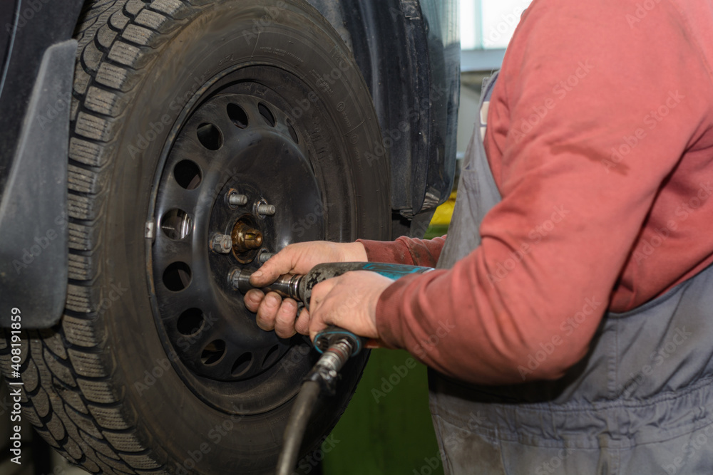 Handyman In Tire Changing In A Power Station With A Impact Driver Stock