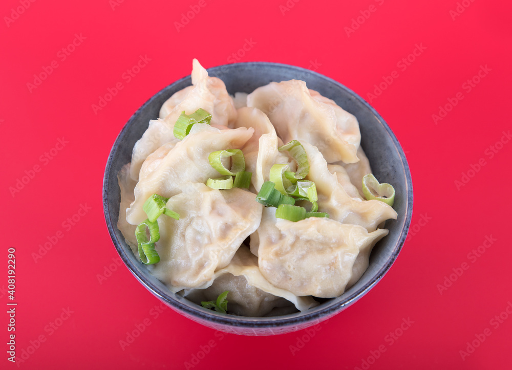 A bowl of dumplings on a red background A bowl of dumplings on a red background
