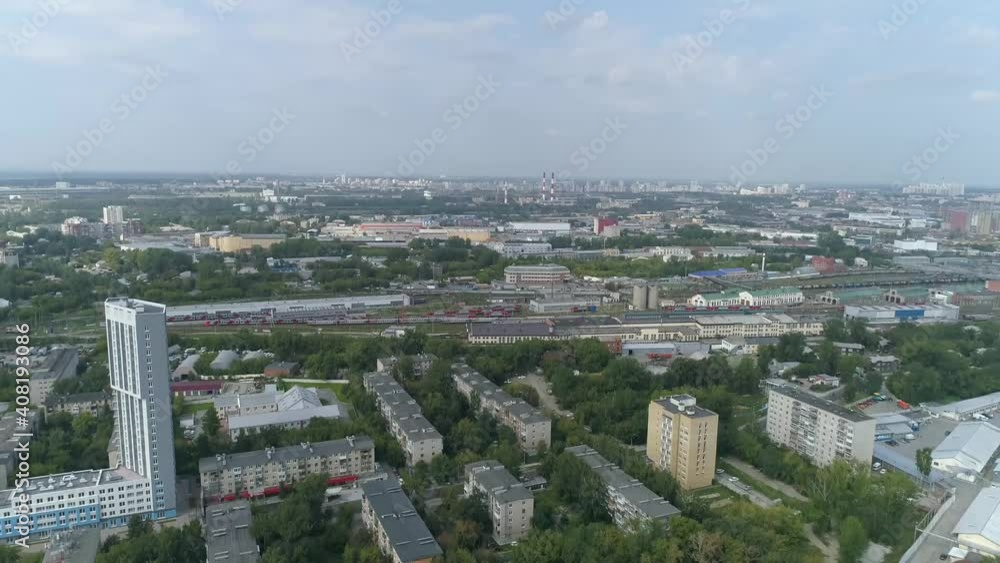 Aerial view of preschool building in residential area with Playgrounds Among trees and children's drawings on the asphalt. Big city with multi-storey buildings. Near railway and trains
