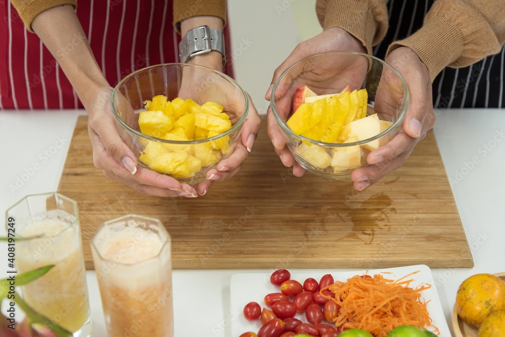 Man and woman couple family preparing healthy food and beverage together in modern kitchen room