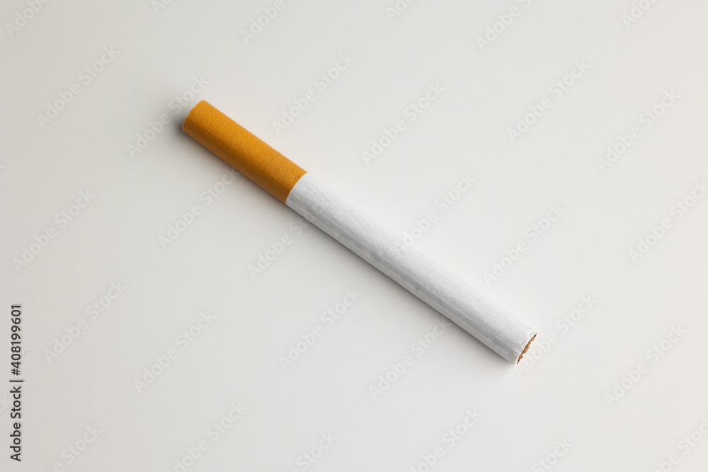 A cigarette is placed on a white table. Take a photo in the studio A cigarette is placed on a white table. Take a photo in the studio