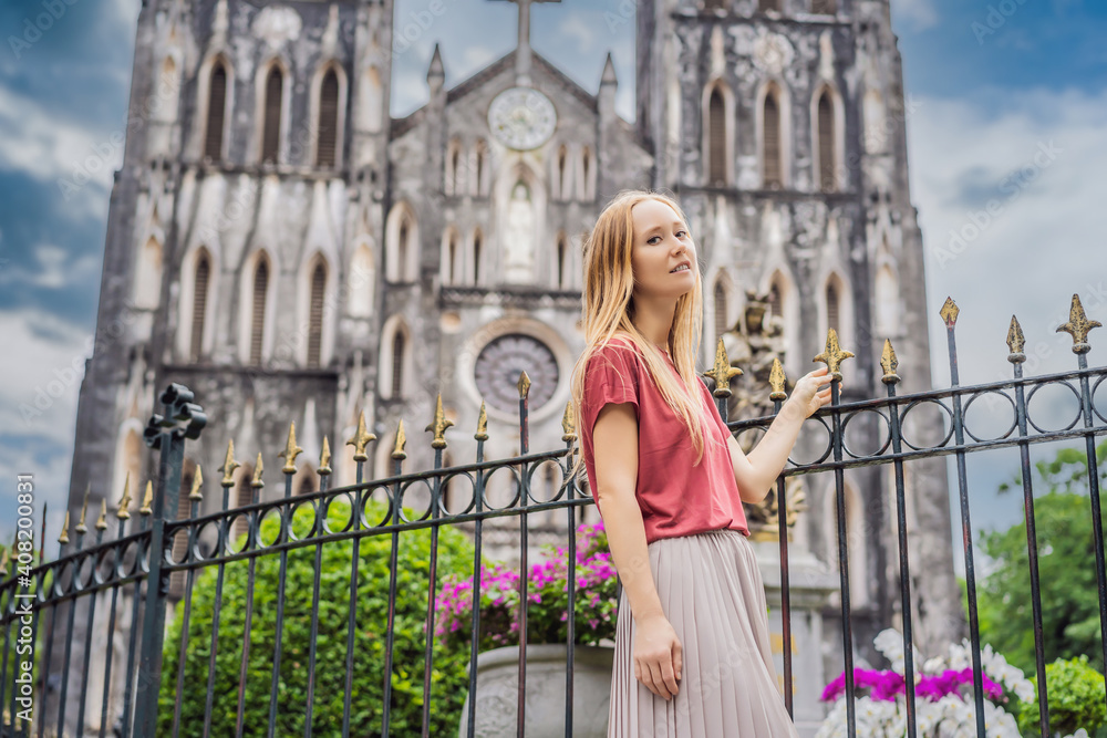 Young woman tourist on background of St Joseph's Cathedral in Hanoi. Vietnam reopens after coronavirus quarantine COVID 19