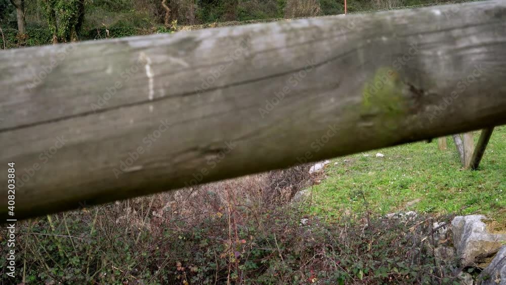 Overgrown abandoned drainage canal with stone wall and wooden log fence Overgrown abandoned drainage canal with stone wall and wooden log fence