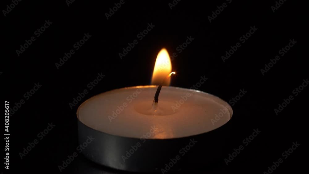 Macro burning small round candle flame isolated on black background, 4K video Macro burning small round candle flame isolated on black background, 4K video