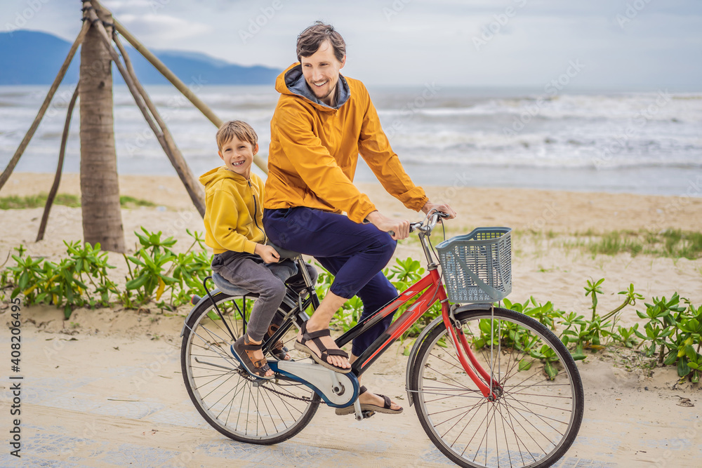 Father with his son having a weekend excursion on bike on a summer day in beautiful landscape