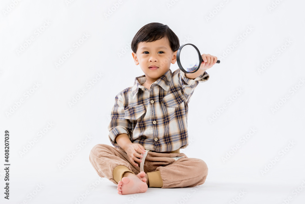 Child holding magnifying glass on white background. Boy with a magnifying glass in studio. Child holding magnifying glass on white background. Boy with a magnifying glass in studio.