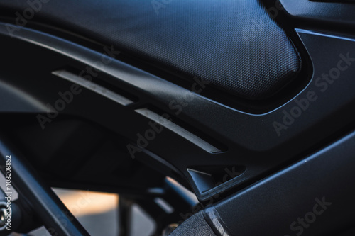 Closeup color shot of modern motor bike parts in dark tone background.