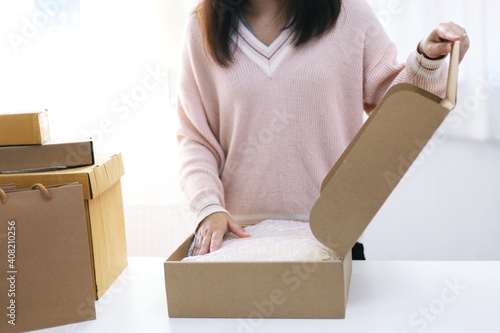 Business From Home woman preparing package delivery box Shipping for shopping online. young start up small business owner at home online order shopping © Charlie's