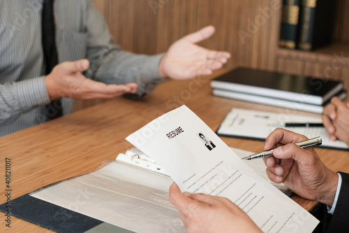 Examiner reading a resume during job interview at office Business and human resources concept