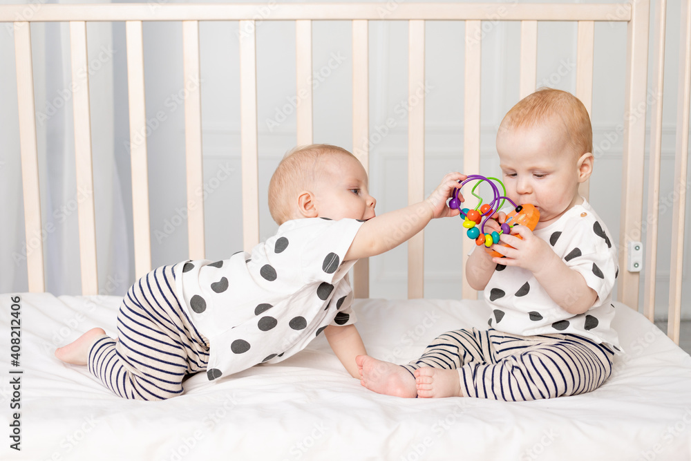 two twin babies play in the crib, the concept of the relationship of
