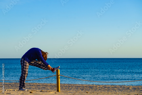 Woman exercising on beach at morning. photo