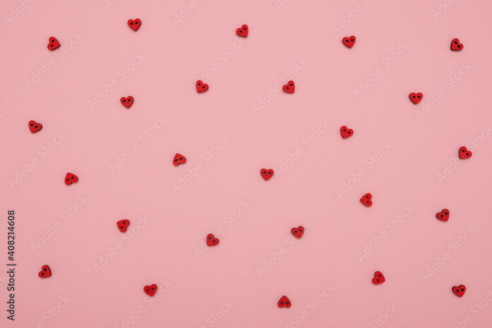 Red wooden love hearts on pink pastel background