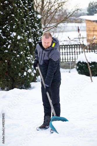 Man Clearing Snow From Path With Shovel