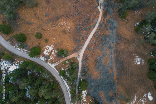 Vertical aerial drone view of masrshes at Rakitna lake in central Slovenia in the middle of the winter on a cloudy day. Visible different colors of soil and water.