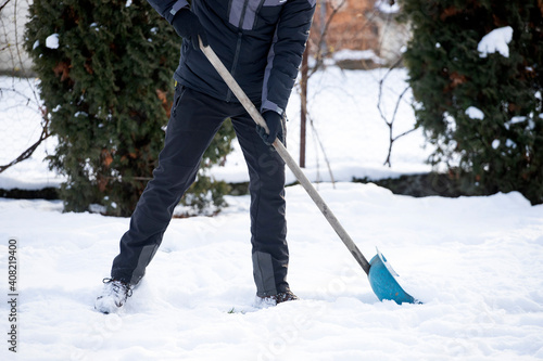 Man Clearing Snow From Path With Shovel