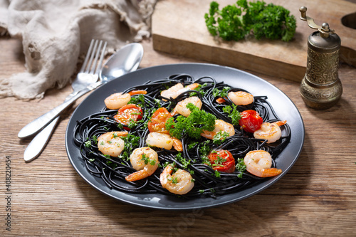 Fényképezés plate of black pasta with shrimps and vegetables