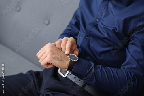 Young businessman with wristwatch in office  closeup