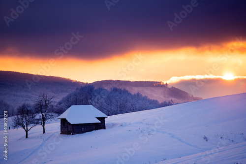 Small cottage in magic sunset in winter mountains © erika8213